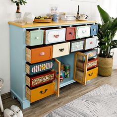 a multicolored dresser with lots of drawers on it and plants in the corner