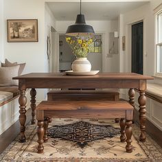 a wooden table sitting in the middle of a living room next to a couch and window