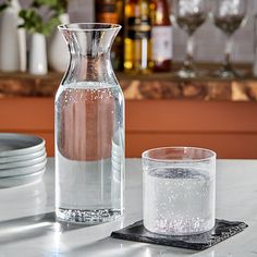 a pitcher and glass sitting on a table