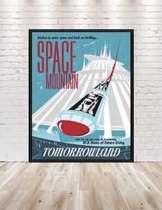 a space mountain poster hanging on a brick wall in an empty room with wood flooring