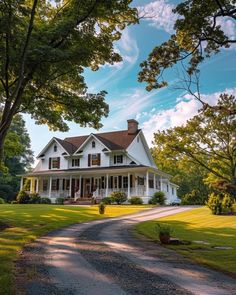 a large white house sitting in the middle of a lush green field next to trees