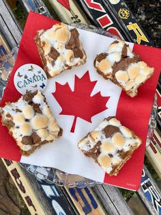 four pieces of food sitting on top of a red and white napkin with a maple leaf