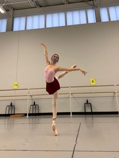 a young ballerina is practicing her ballet moves