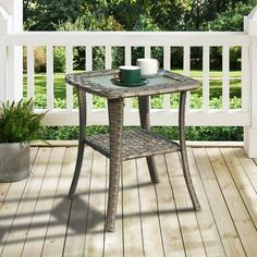 a table on a porch with a potted plant next to it