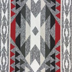 a red, white and black rug with an abstract design on it's side