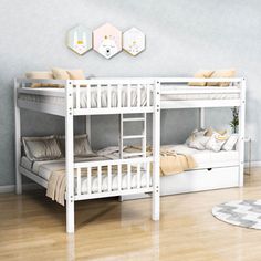 a white bunk bed sitting on top of a hard wood floor next to a rug