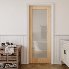 a bathroom with a wooden door and white walls