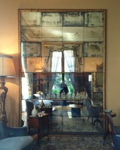 a living room filled with furniture and a large mirror