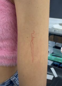 a woman's arm with a small red line drawing on the back of it