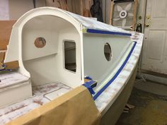 a white boat being built in a shop