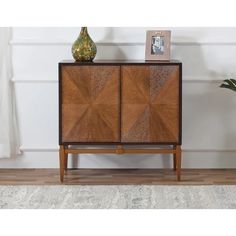 a wooden cabinet sitting on top of a hard wood floor next to a potted plant