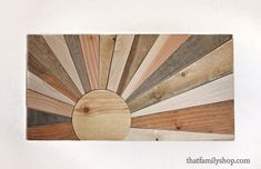 a wooden wall hanging with different colored wood planks in the shape of a sunburst