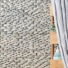 a wall made out of woven material next to a shelf with vases on it