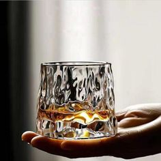 a hand holding a glass filled with liquid