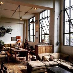 a living room filled with lots of furniture and large windows above it's walls