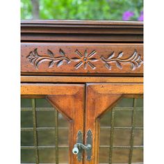 an ornate wooden cabinet with glass doors