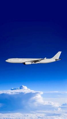 an airplane is flying in the sky above some clouds and blue skies with white fluffy clouds