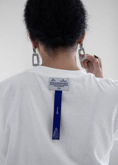 the back of a woman's white shirt with a blue ribbon around her neck