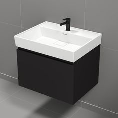 a black and white bathroom sink sitting on top of a tiled floor next to a wall