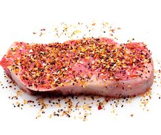 a piece of raw meat with sprinkles on the top and bottom half