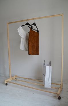 two bags are hanging on a clothes rack