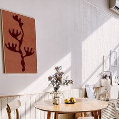 a table and chairs in a room with a painting on the wall