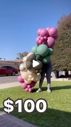 a giant bunch of balloons sitting on top of a lush green field