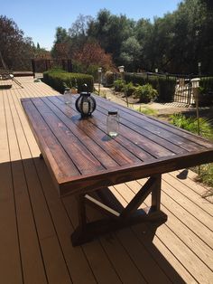 a wooden table sitting on top of a wooden deck