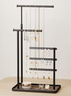 a jewelry rack with several necklaces hanging from it's sides on a wooden table