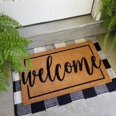 a welcome mat with the word welcome on it sitting next to a potted plant