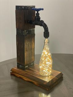 a light bulb in a glass bottle sitting on top of a wooden stand next to a faucet