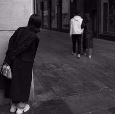 two people standing next to each other on a sidewalk