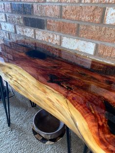 a wooden bench sitting next to a brick wall on top of a carpeted floor