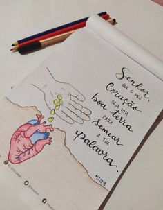 a drawing of a hand holding a heart on top of a piece of paper next to colored pencils