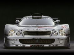 a silver mercedes race car parked in front of a black background