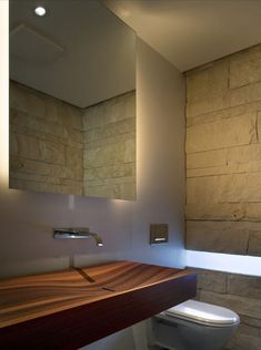 a bathroom with a wooden counter top next to a toilet