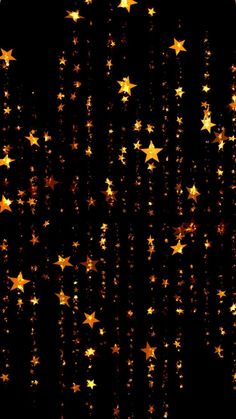 gold stars are falling down on a black background