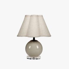 a table lamp with a white shade on it's base and a light bulb in the shape of a ball