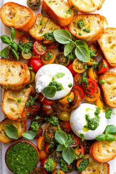 tomatoes, basil, mozzarella and pesto on a white platter with bread