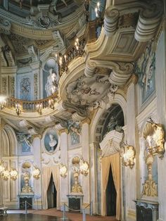 an ornate room with chandeliers and paintings on the walls