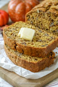 two slices of banana bread with butter on top and some tomatoes in the back ground