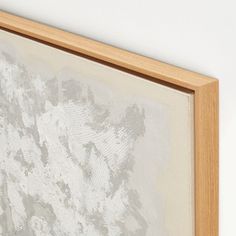 a painting hanging on the wall next to a wooden framed object with white paint and wood trim