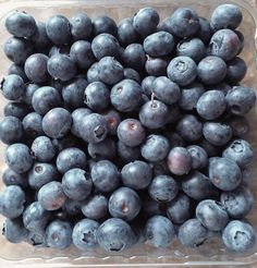 blueberries are piled up in a glass bowl