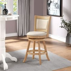 a white bar stool sitting next to a table with a vase on top of it