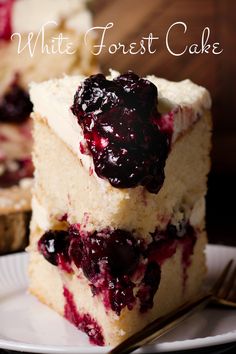 a white frosted cake with blueberries on top