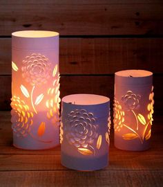 three lit candles sitting on top of a wooden table