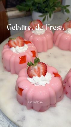 strawberry jellos with whipped cream and fresh strawberries arranged on a marble platter