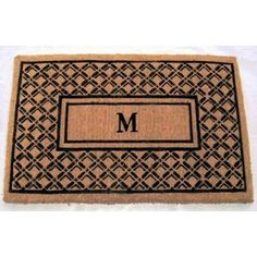 a monogrammed door mat with the letter m in black and tan on it