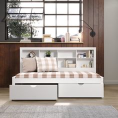 a white bed with drawers underneath it