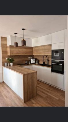 a kitchen with wooden floors and white cabinets